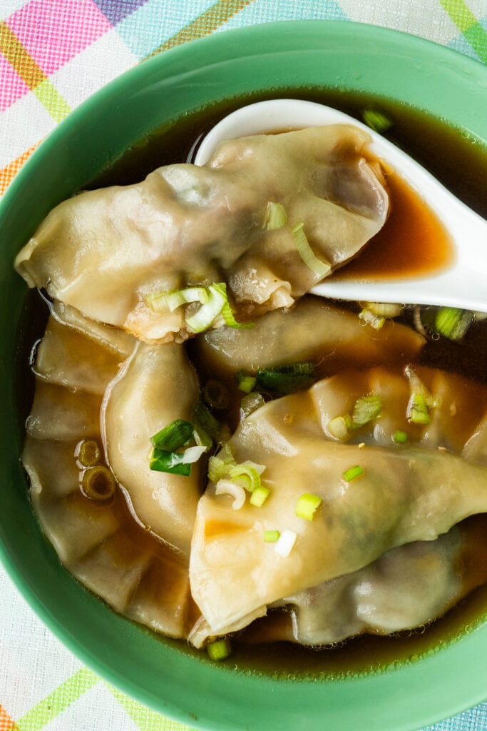closeup of dumpling soups with spoon.