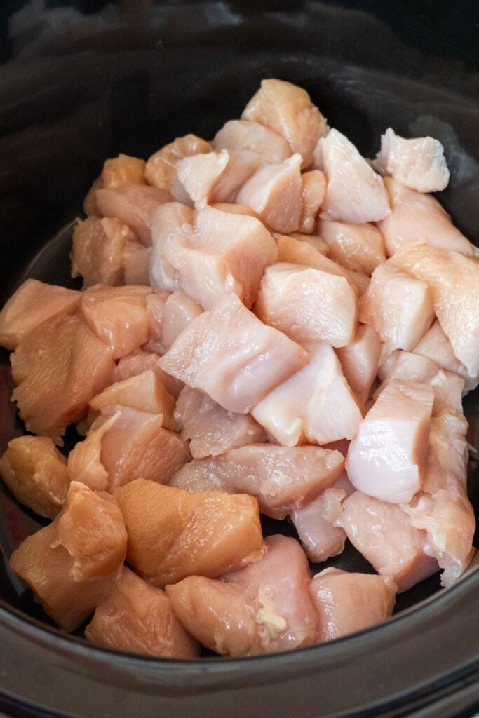 diced raw chicken in slow cooker.