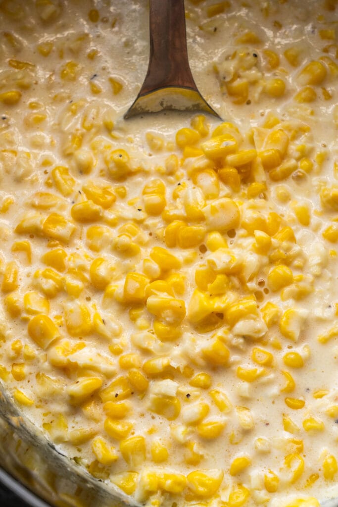 spoon stirring creamed corn in crockpot.
