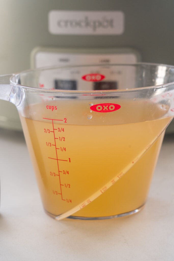 chicken broth in a measuring cup.