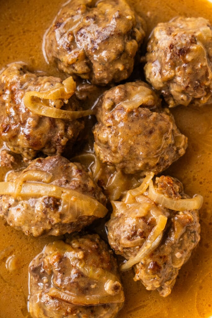 closeup of hamburger steaks with onions and beef gravy.