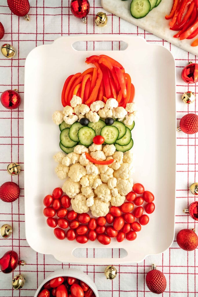 santa vegetable tray on white and red table cloth.