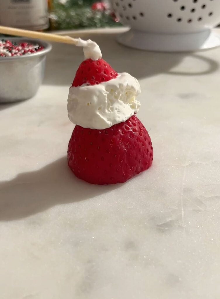 adding pom pom on to strawberry hat using cool whip.