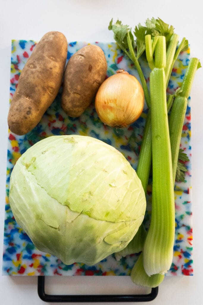 cabbage and other vegetables on cutting board.