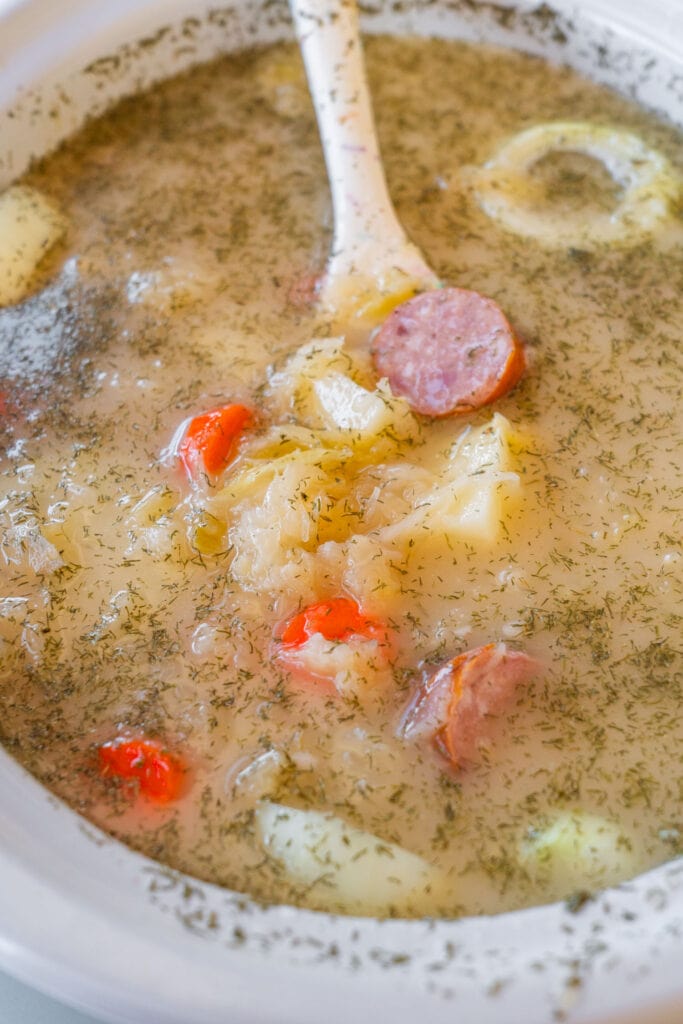 spoon stirring soup in crockpot.