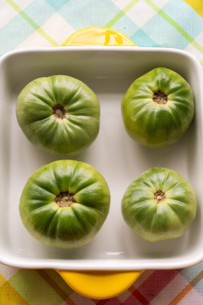 whole green tomatoes in baking dish.