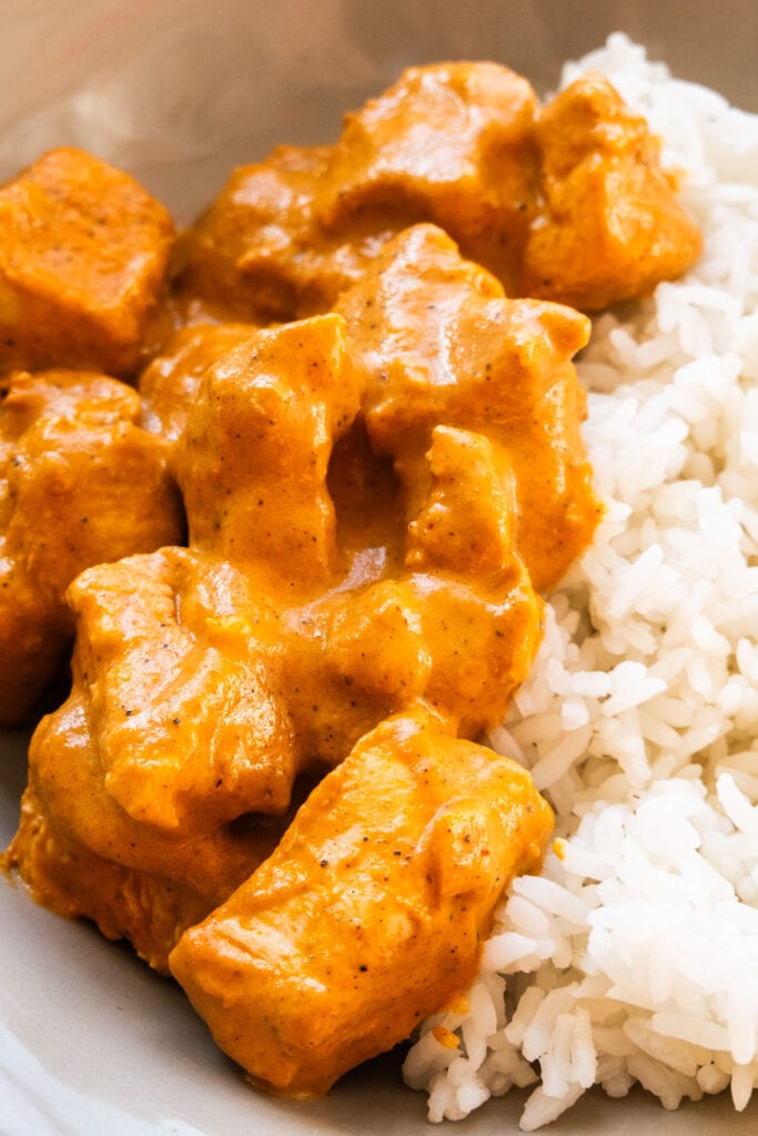creamy butter chicken with rice on plate.