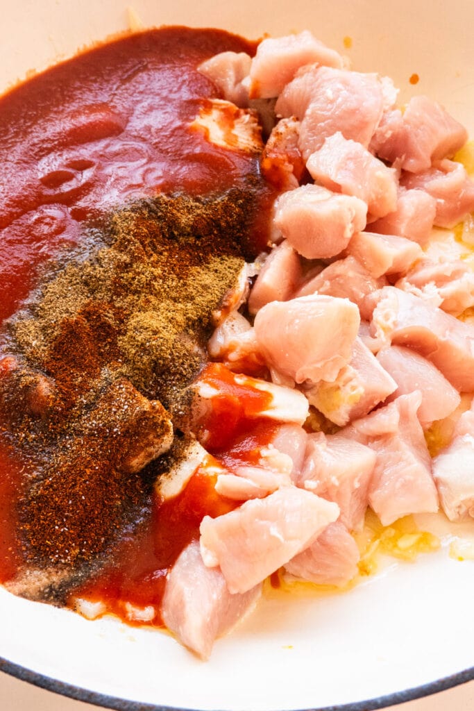 chicken breast, tomato sauce, spices in skillet.