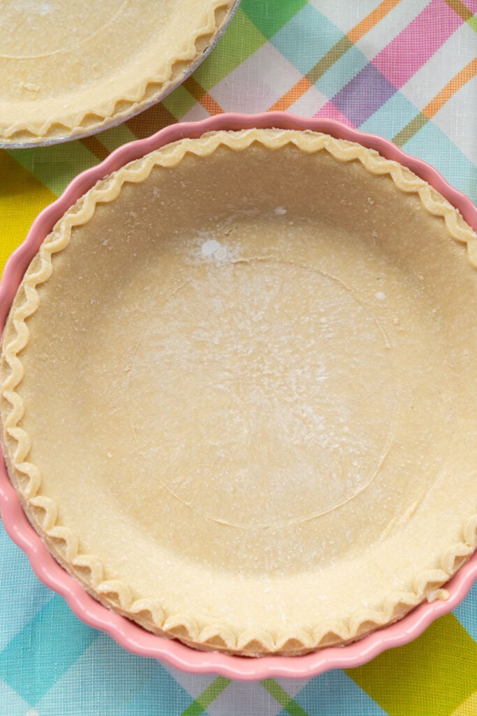 thawed pie crust in pink pan.