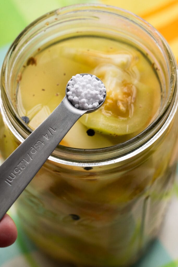 pickle crisp granules being added into mason jar.