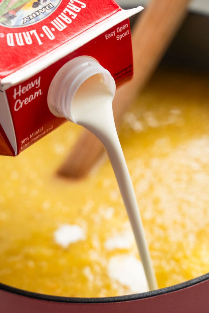 heavy cream being poured into pot.