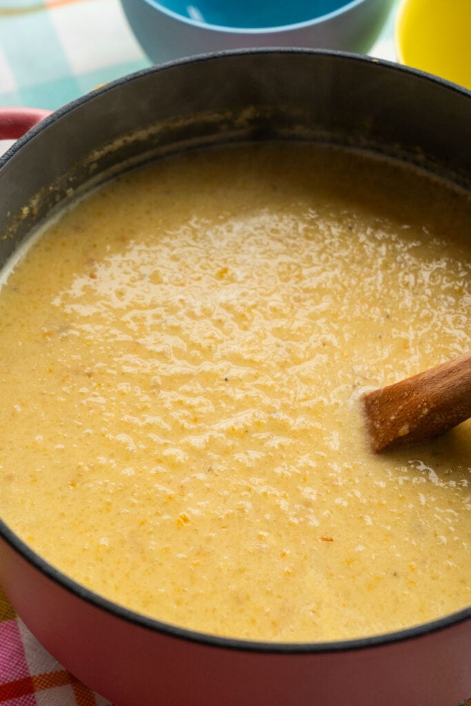 spoon stirring creamy tomato soup.