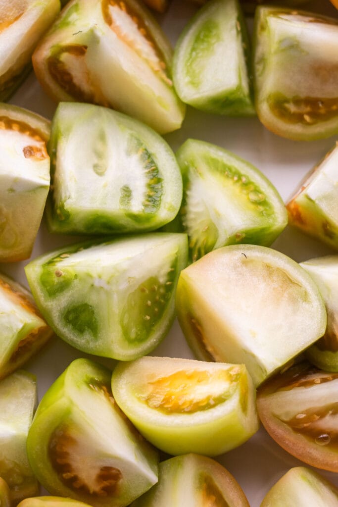 quartered green tomatoes in baking dish.