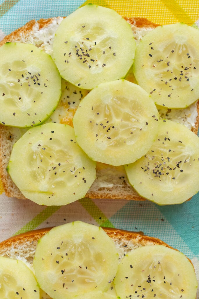 slices of cucumber with salt and pepper on bread.