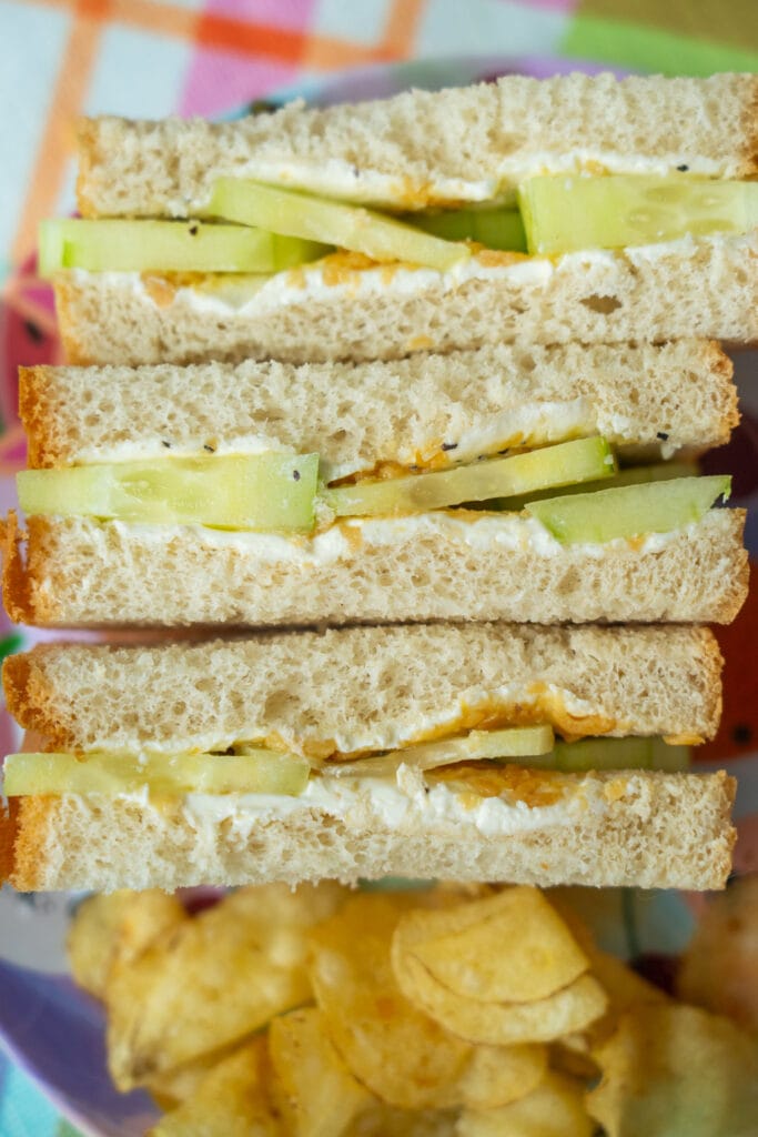 cucumber sandwich with potato chips on plate.