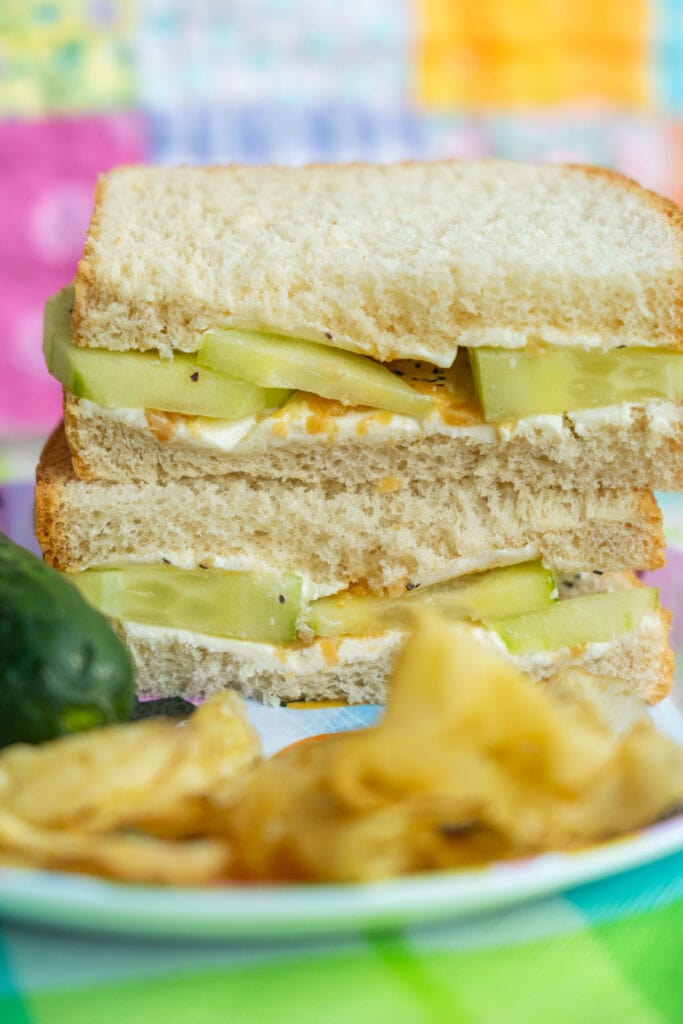 sandwiches with potato chips and pickle on plate.