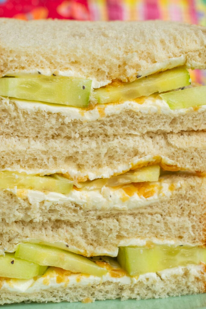 closeup of cucumber sandwich with cucumbers and cream cheese on white bread.