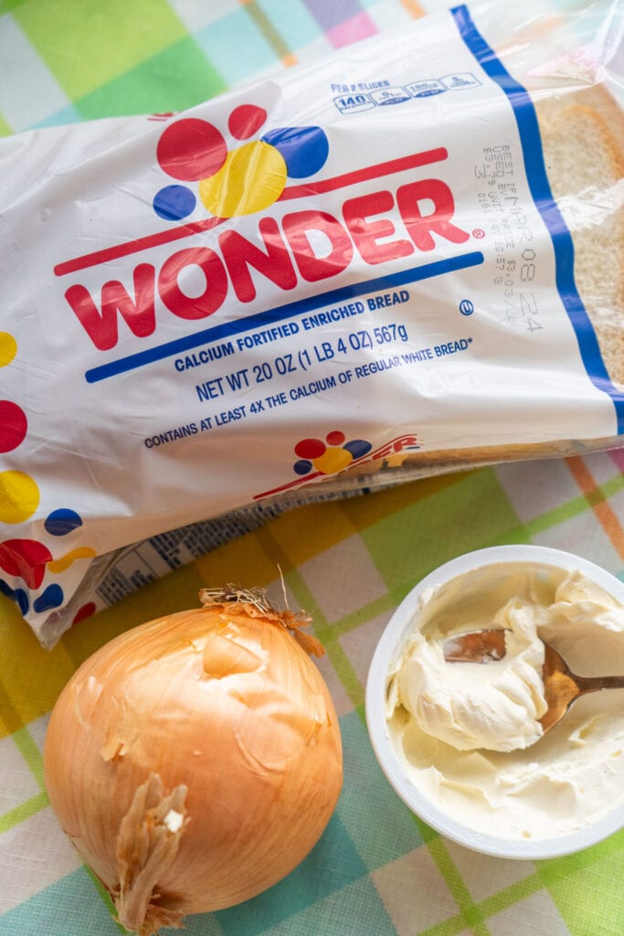 wonder bread, onion and cream cheese on table.