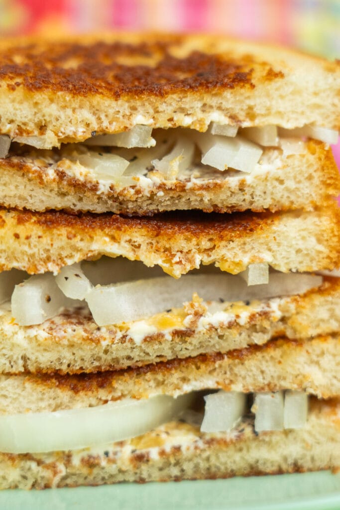 closeup cream cheese and onion sandwich on toasted bread.