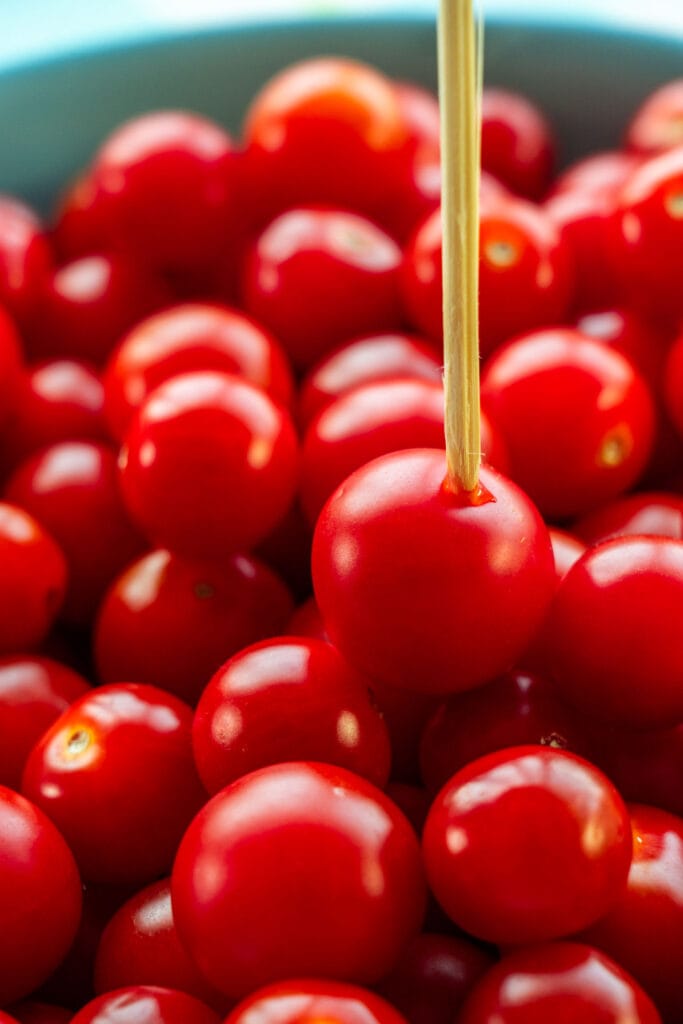 toothpick going through cherry tomatoes.