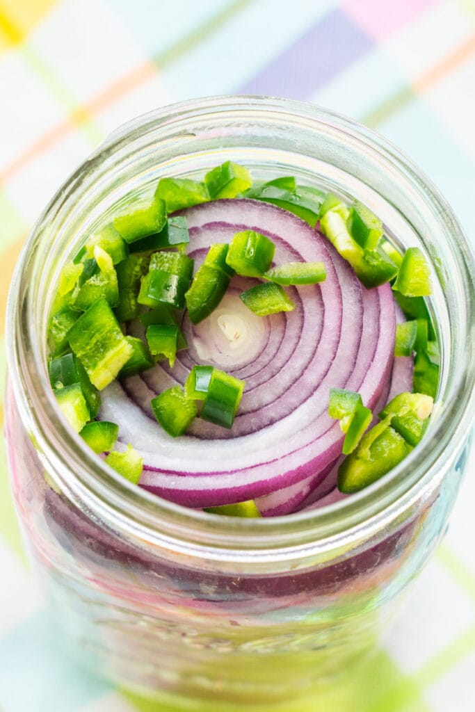 red onions and jalapeno pepper in mason jar.