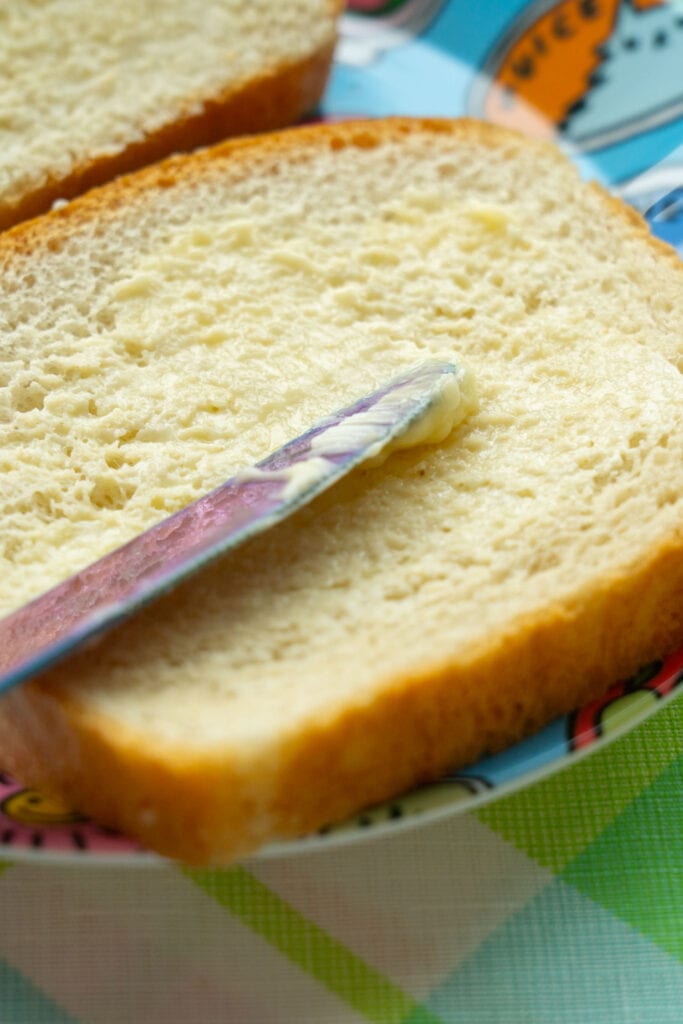 butter being spread on bread.