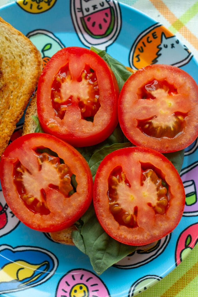 slices of tomatoes on top of basil. 