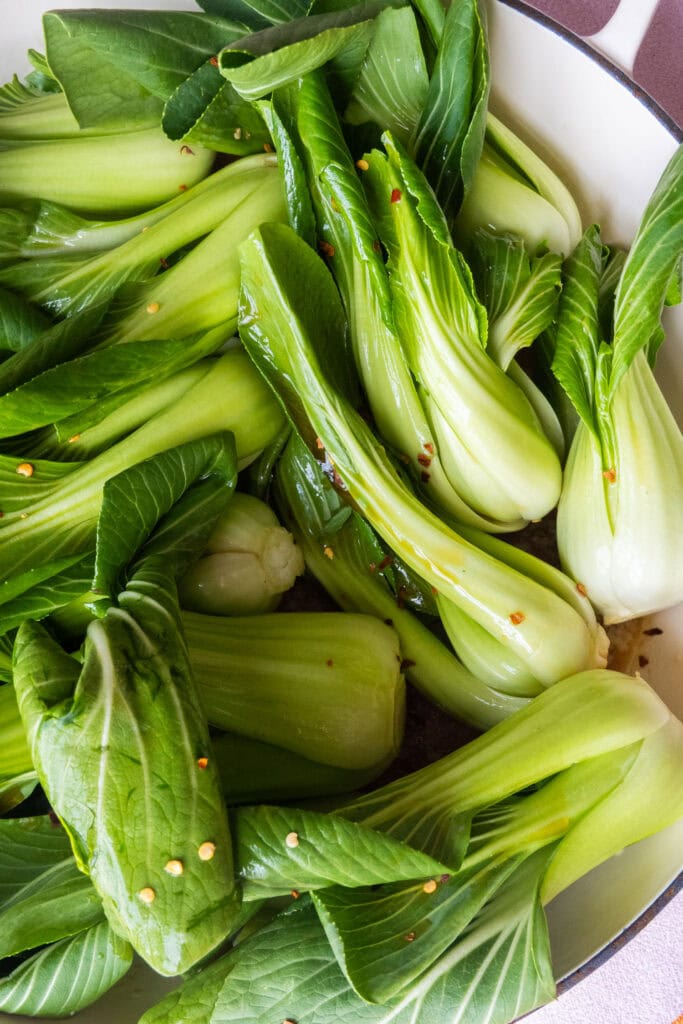 bok choy in skillet with red pepper flakes.