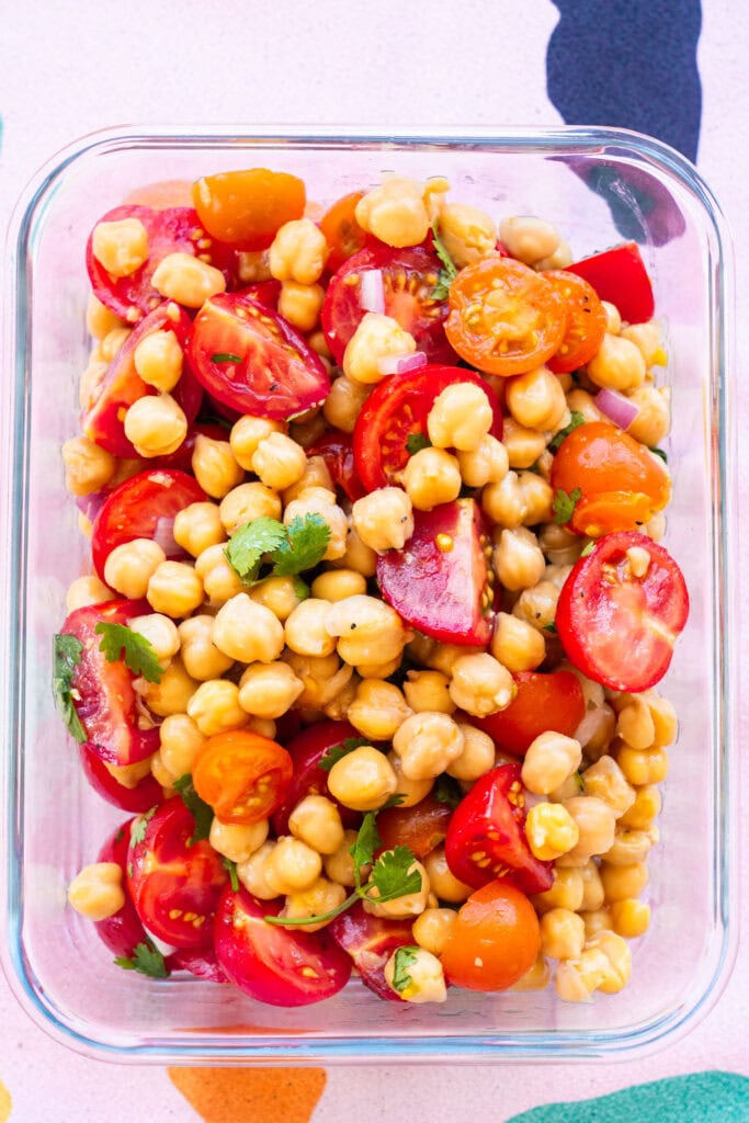 chickpea and tomato salad in glass container.