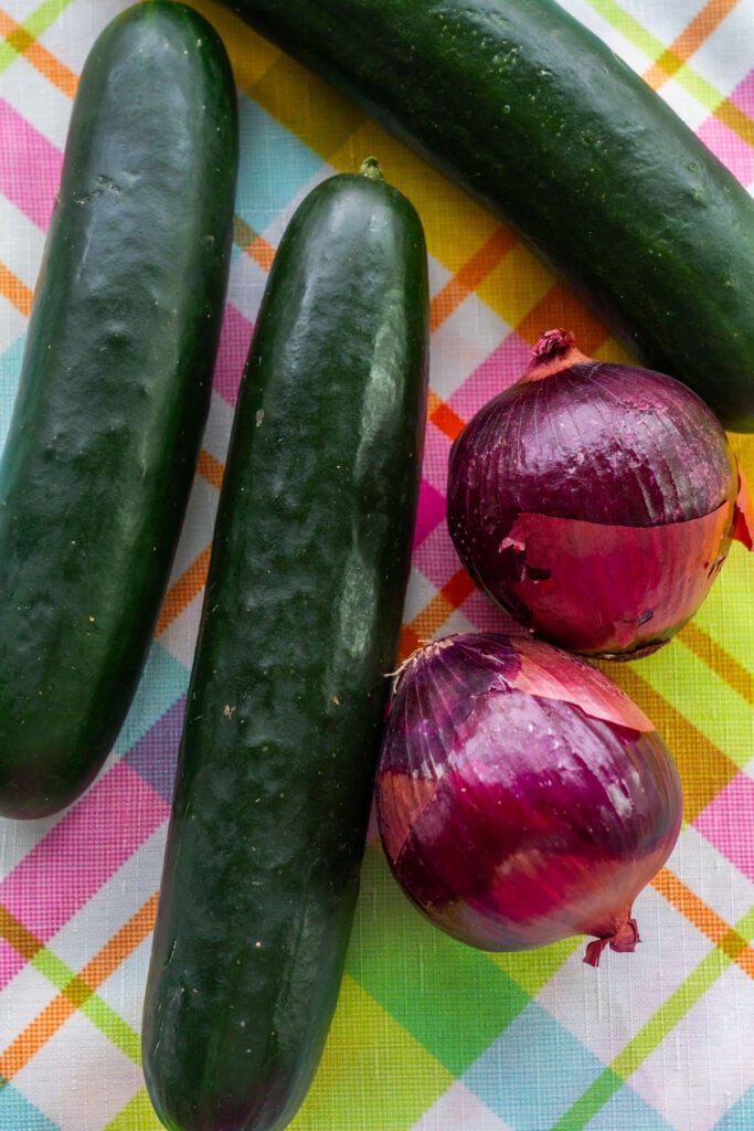 cucumbers and red onions on table.