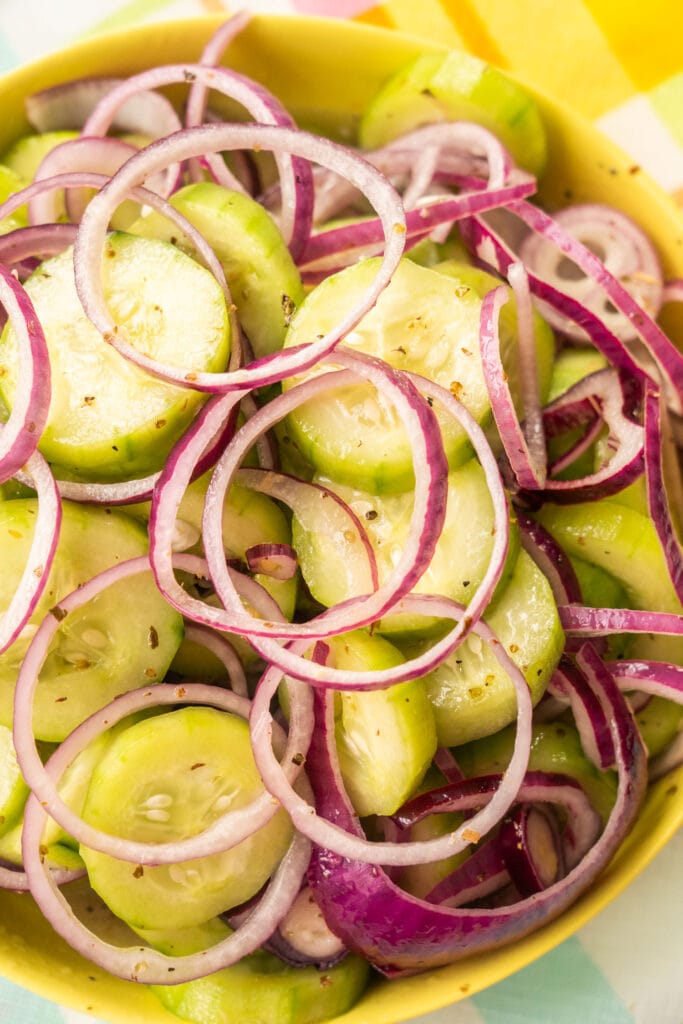 cucumber red onion salad in yellow bowl ready to be served.