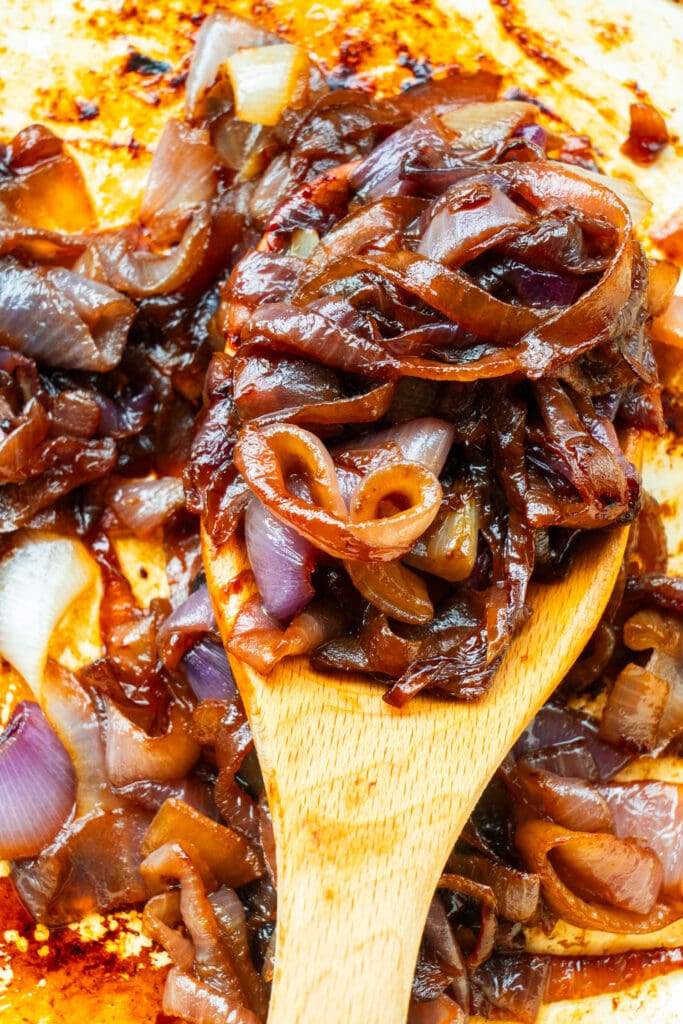 spoon filled with caramelized onions.