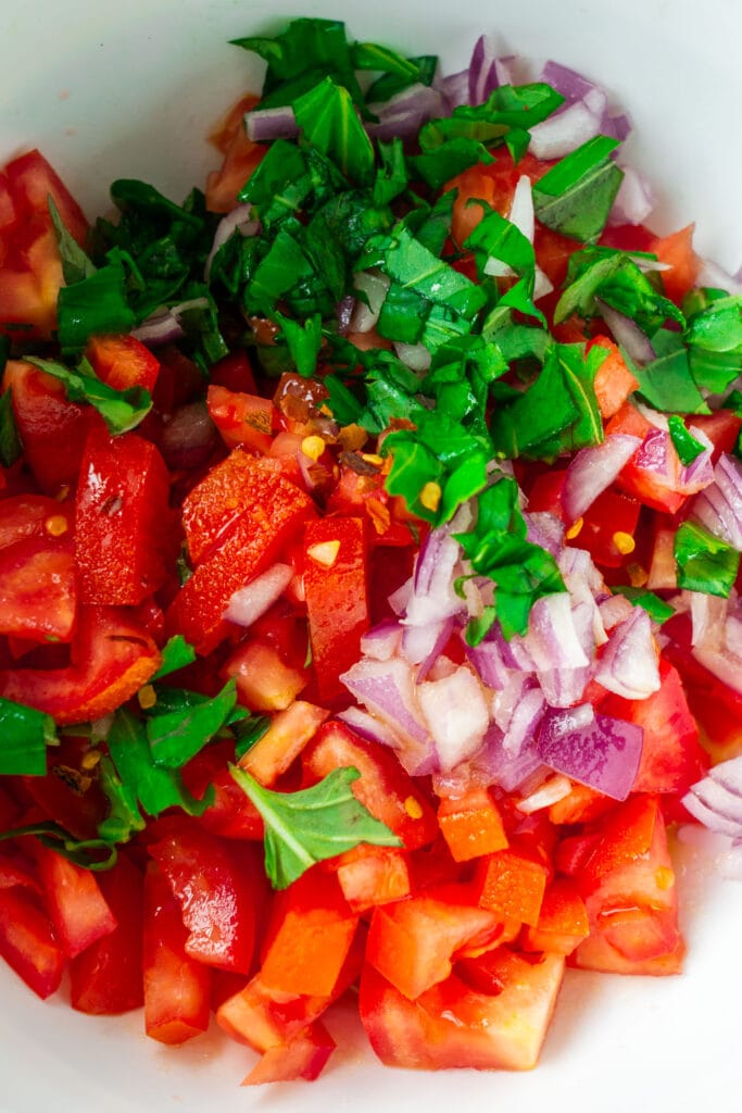 tomatoes, onions and basil in mixing bowl. 