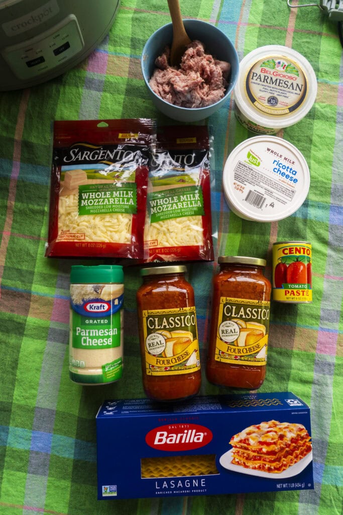 ingredients for crockpot lasagna on table with green tablecloth.