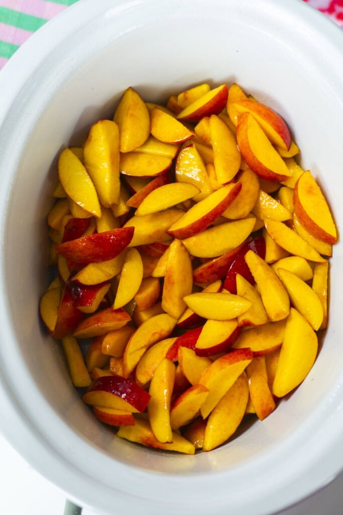 peaches placed in slow cooker bowl. 