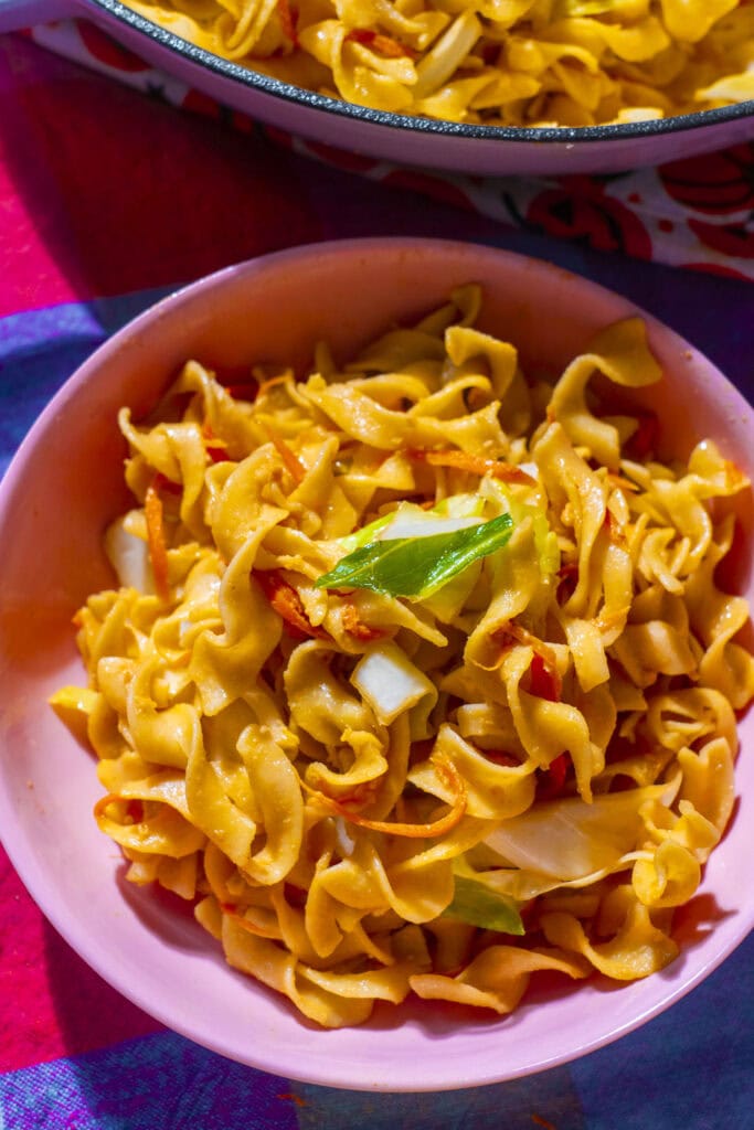 egg noodles on pink plate, ready to be served.