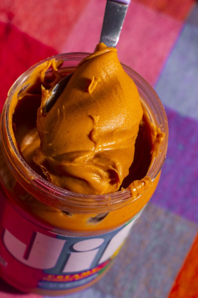 JIF peanut butter coming out of jar on spoon. 