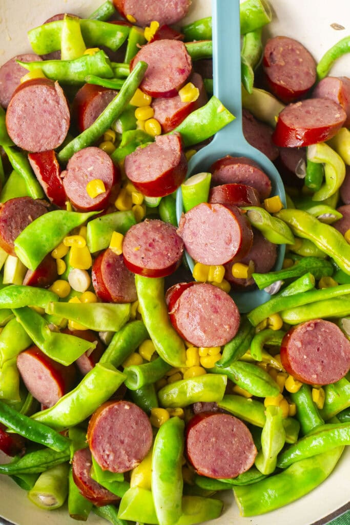 cooked kielbasa, green beans and corn, all buttery in skillet. 