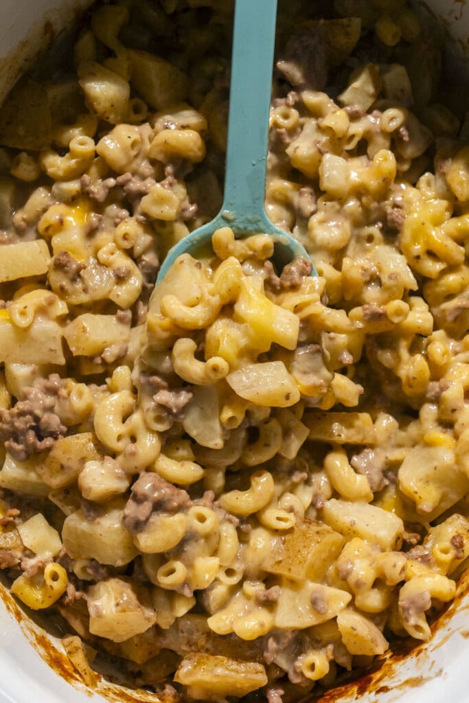 team spoon serving hamburger helper directly out of crockpot.