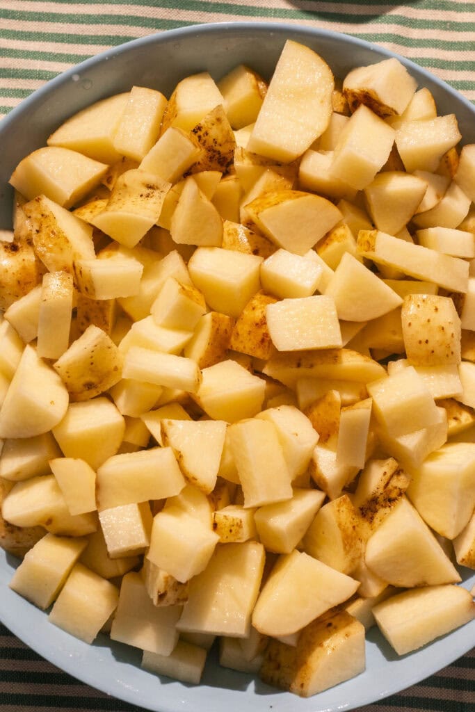 the most beautiful homegrown potatoes diced up in a blue bowl. 