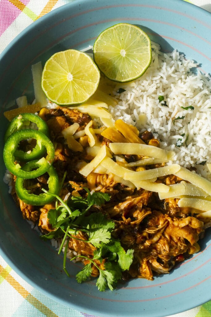 bowl filled with salsa chicken, rice and shredded cheese for rice taco bowls. 