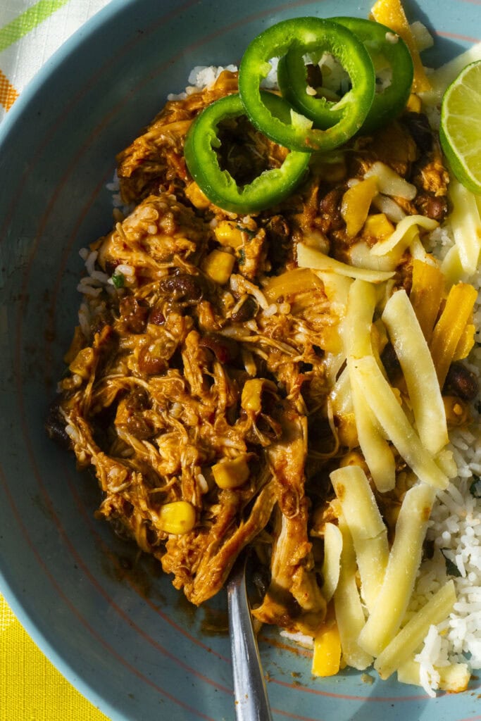 crockpot salsa chicken being served in blue bowl. 