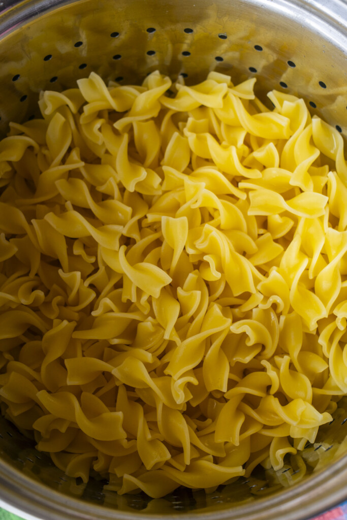cooked egg noodles in strainer.