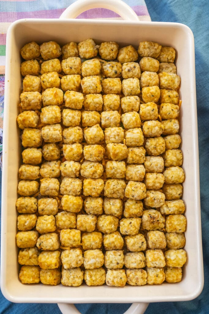 frozen tater tots covering casserole in baking dish.
