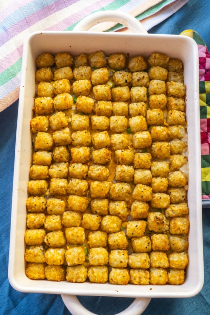 crispy golden brown tater tots on top of baking dish, baked casserole ready to be served.