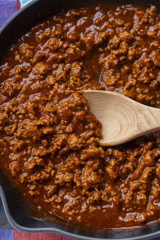 saucy ground turkey being stirred in pan.