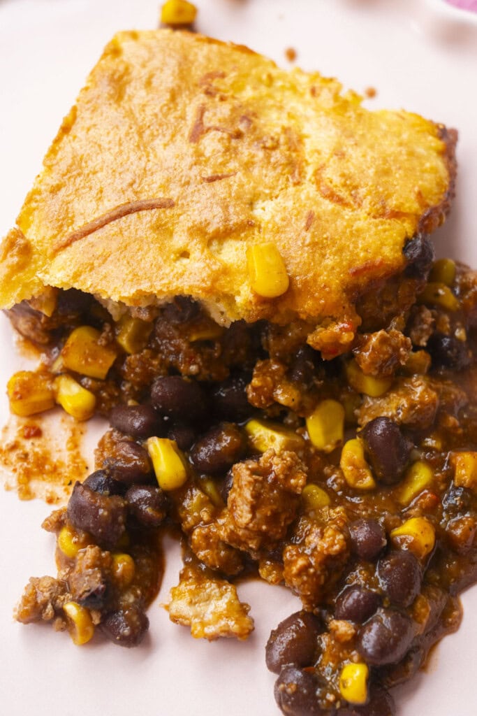 piece of casserole on light pink plate.