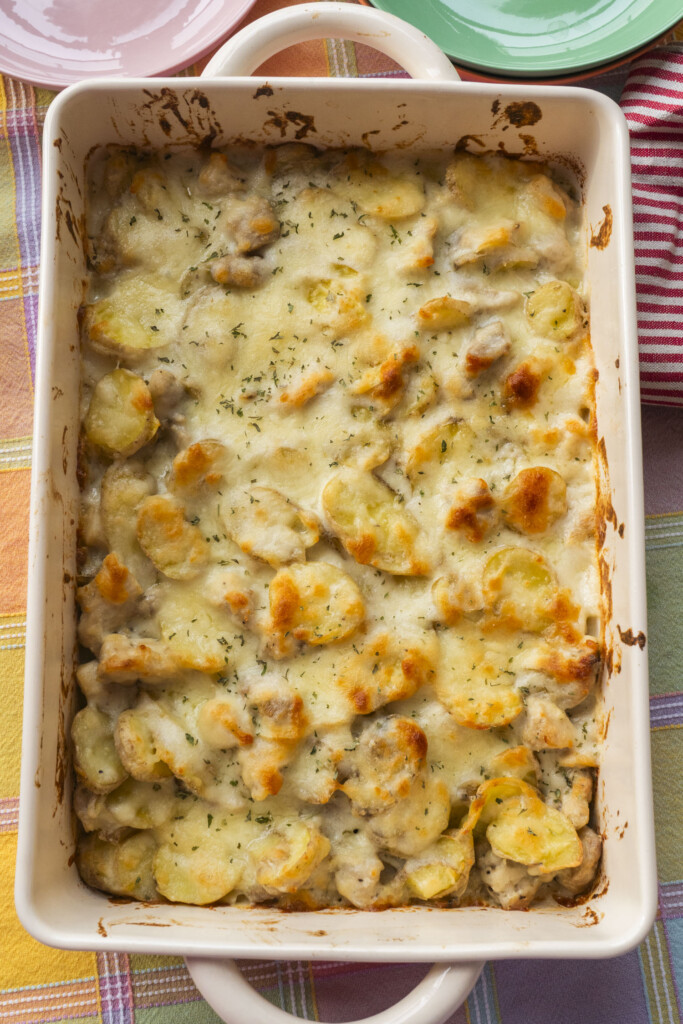 Baked Chicken Alfredo Casserole with golden brown cheese and tender fingerling potatoes in a white baking dish.