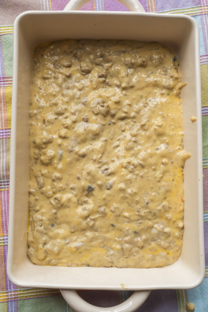 Cheesy ground turkey and Velveeta mixture spread into the bottom of a rectangular baking dish.