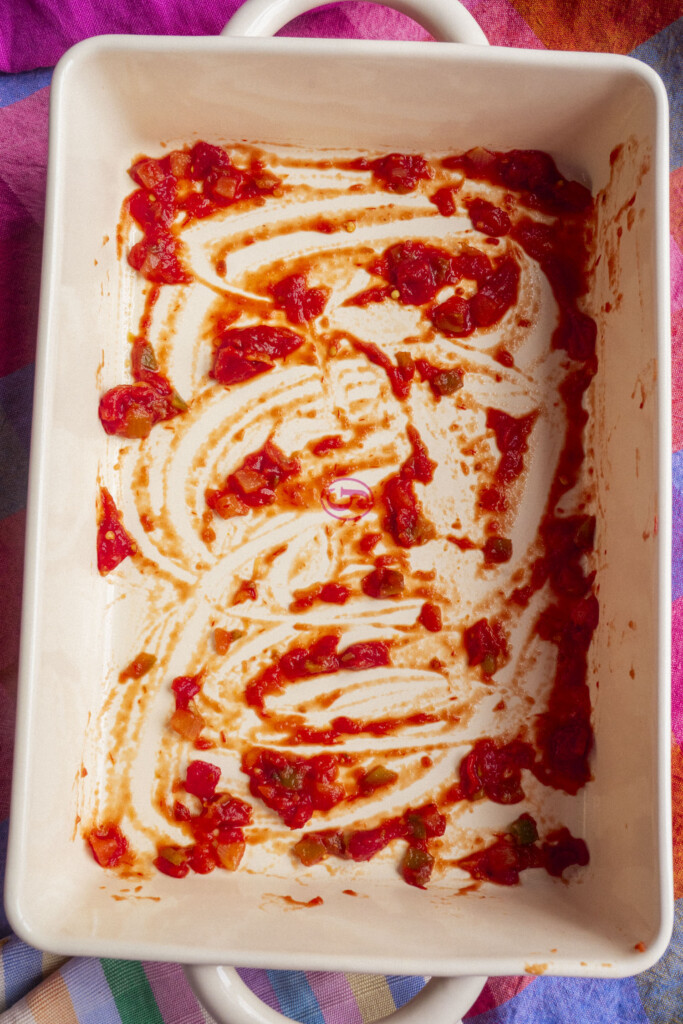 A rectangular white baking dish with traces of salsa on the bottom.